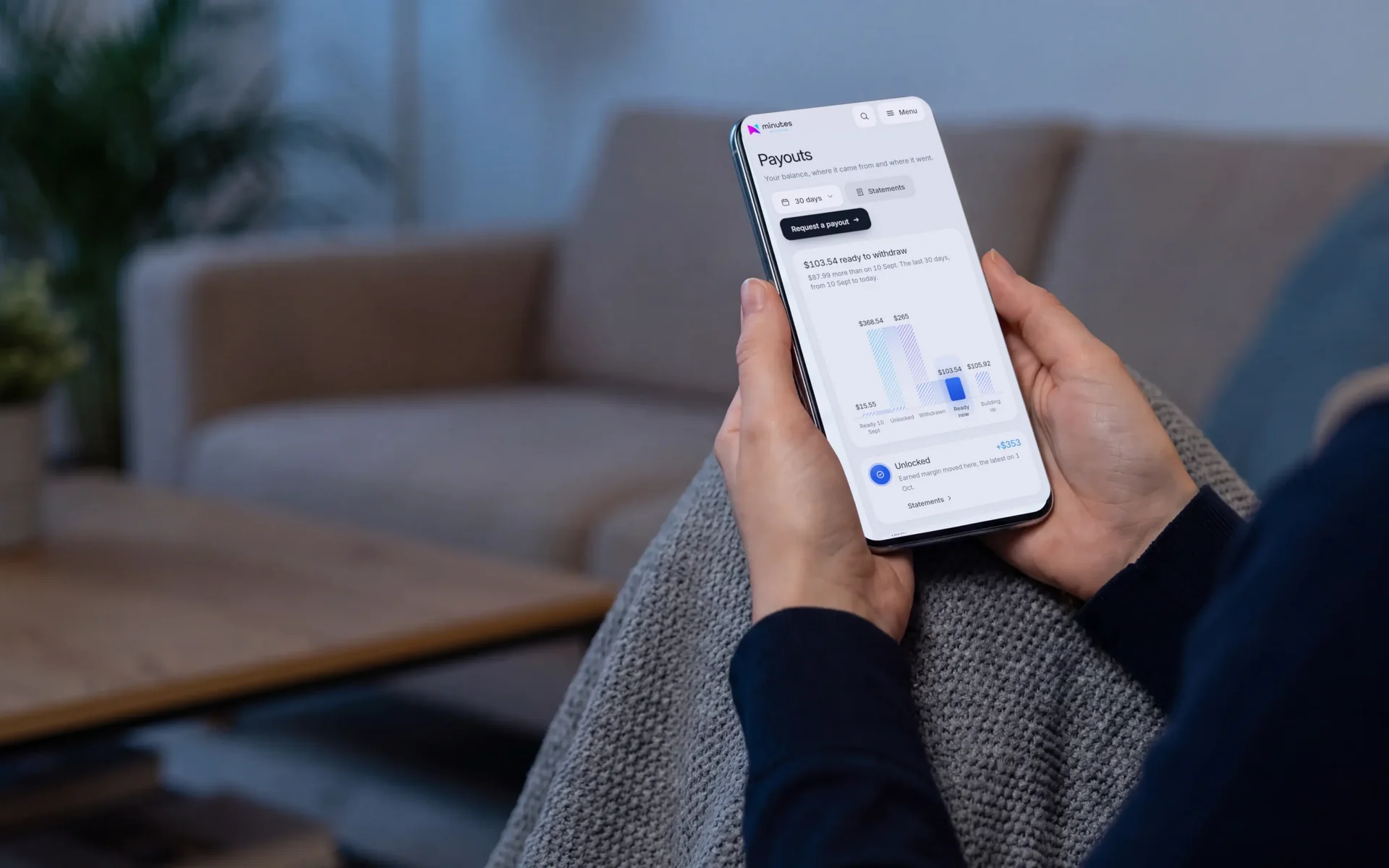 Hands holding a phone showing the Accelerator Payouts page with the balance ready to withdraw